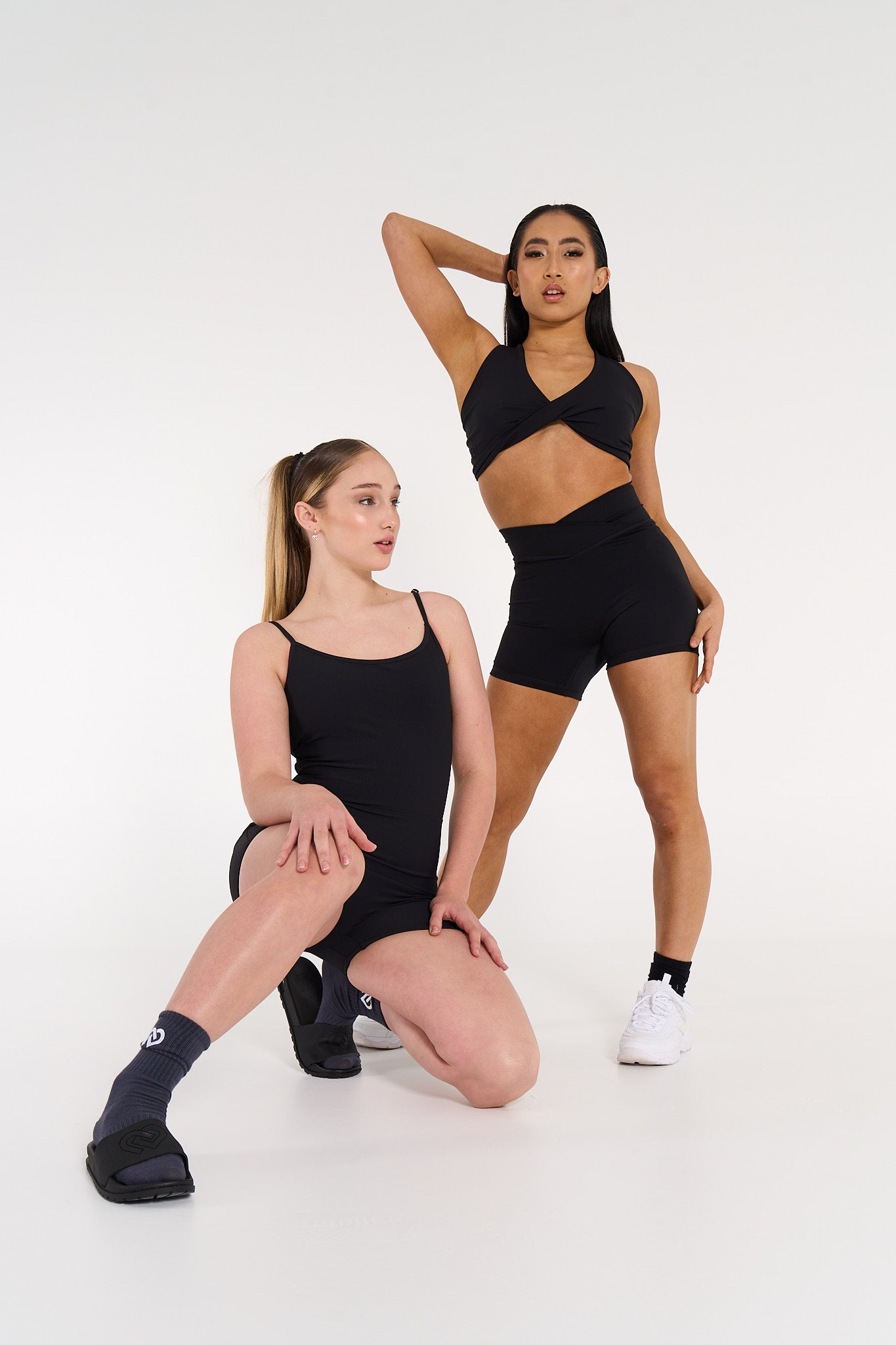 Young women wearing ribbed activewear black bodysuit &amp; activewear black crop &amp; shorts