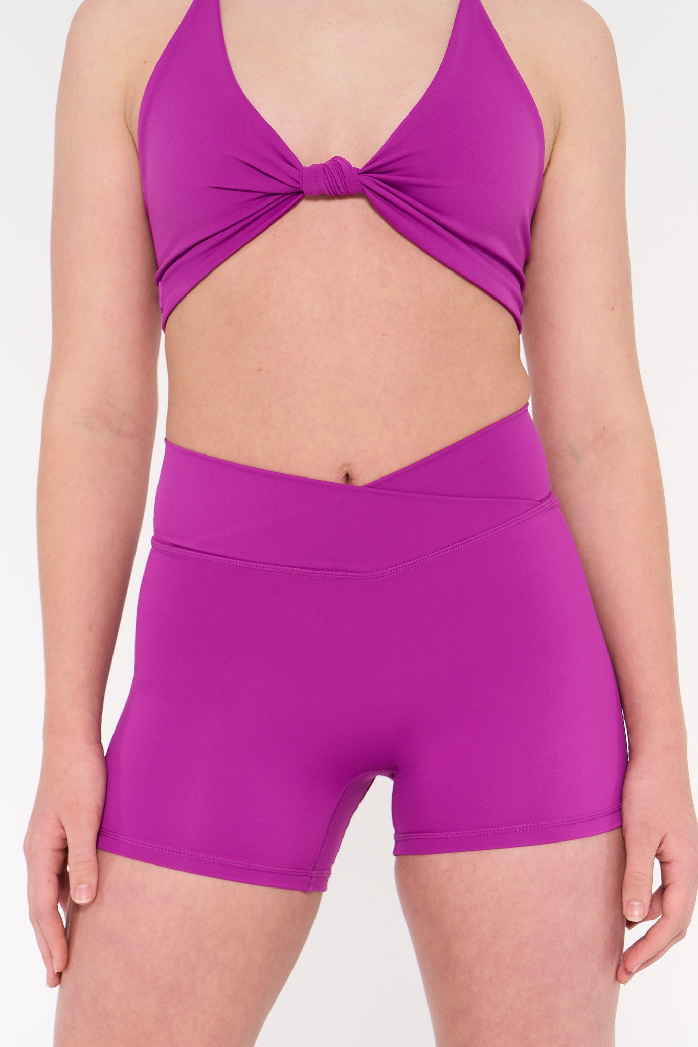 Young woman wears activewear purple v style shorts.