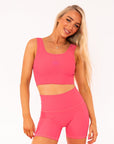 Young woman wearing Hot Pink active wear high waisted bike shorts. 