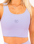 Female wearing Lilac supportive thick strap active wear top. 