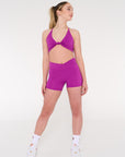 Young woman wears activewear purple v style shorts.