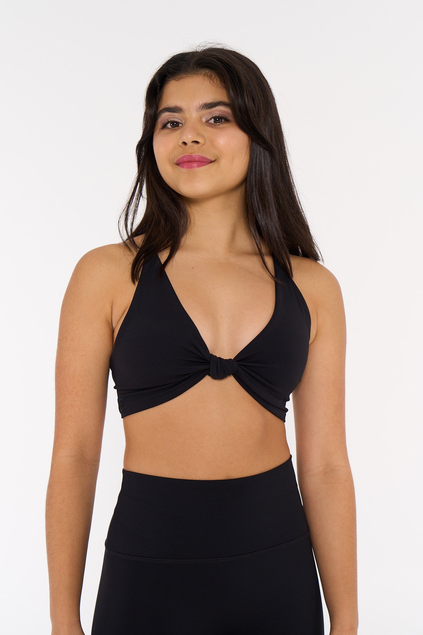young woman wearing black twist knot activewear crop.