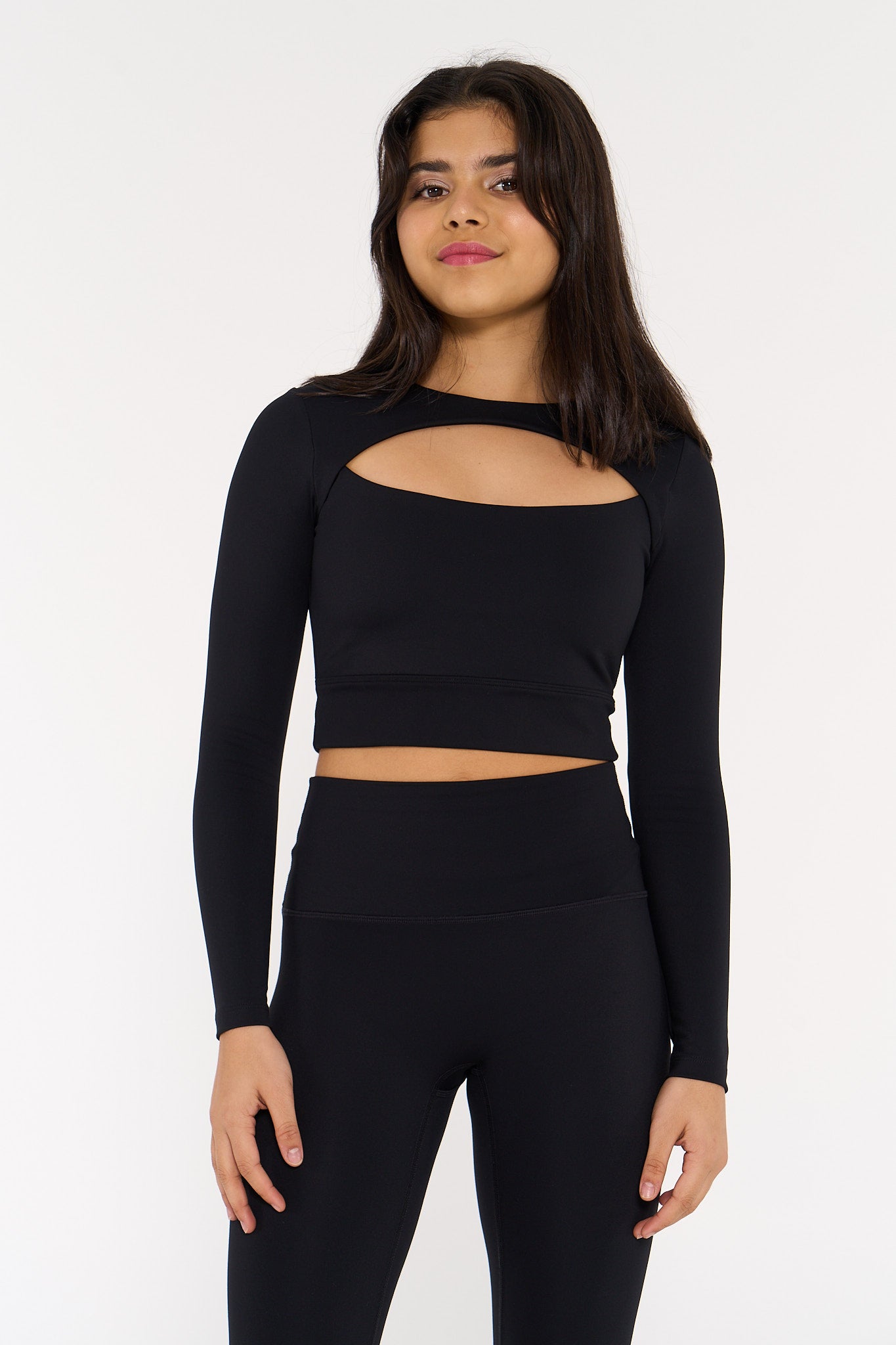 young woman wearing black long sleeve cut out activewear crop.