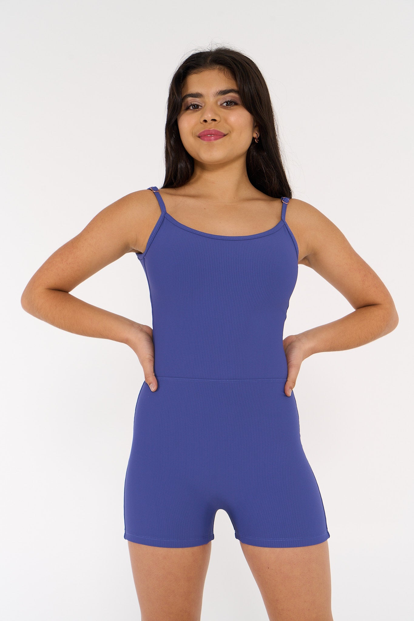 young woman wears indigo coloured activewear bodysuit.