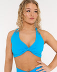 Young woman wearing sea blue activewear twist crop