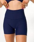 Young woman wearing Navy active wear high waisted bike shorts. 