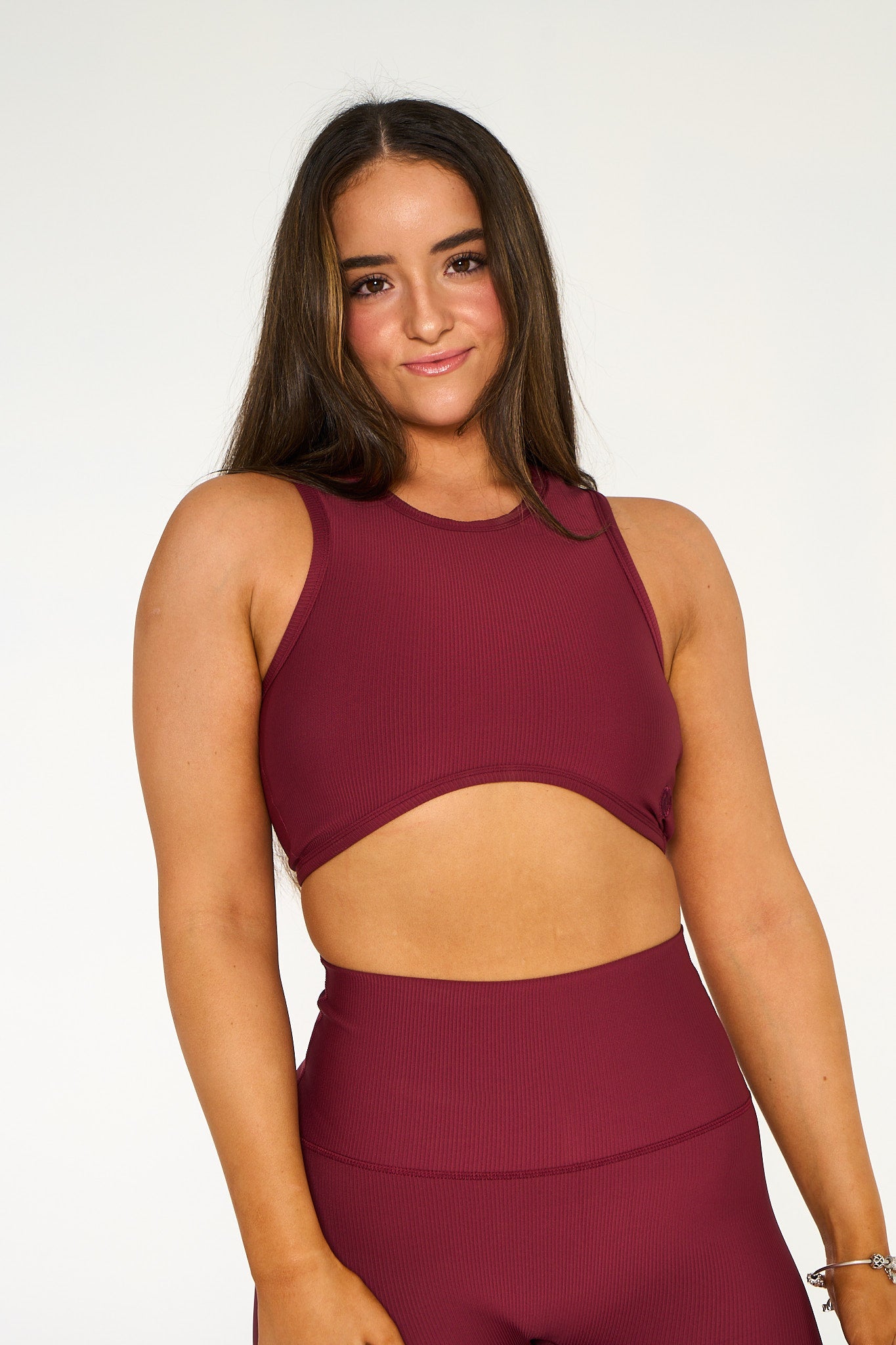 Young woman wearing a deep red heart shaped active wear top. 