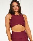 Young woman wearing a deep red heart shaped active wear top. 